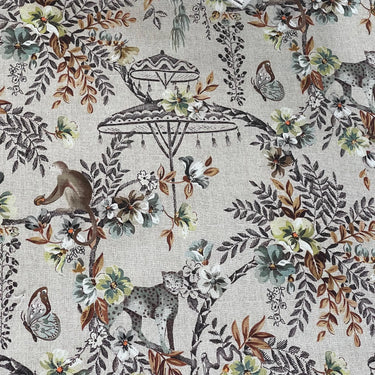 Close-up of Savannah animal fabric with monkeys and tropical flowers, showcasing fine detail on a textured natural base — great for accent cushions and drapery.